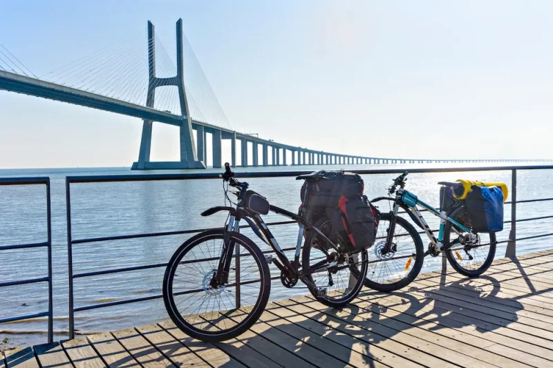 Bicicletas con alforjas estacionadas con vista a un gran puente
