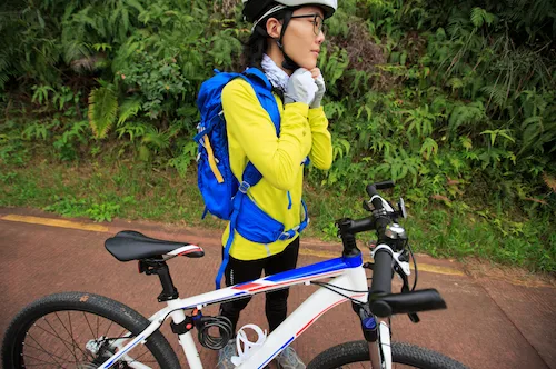 Ciclista asiática colocándose su casco de bicicleta
